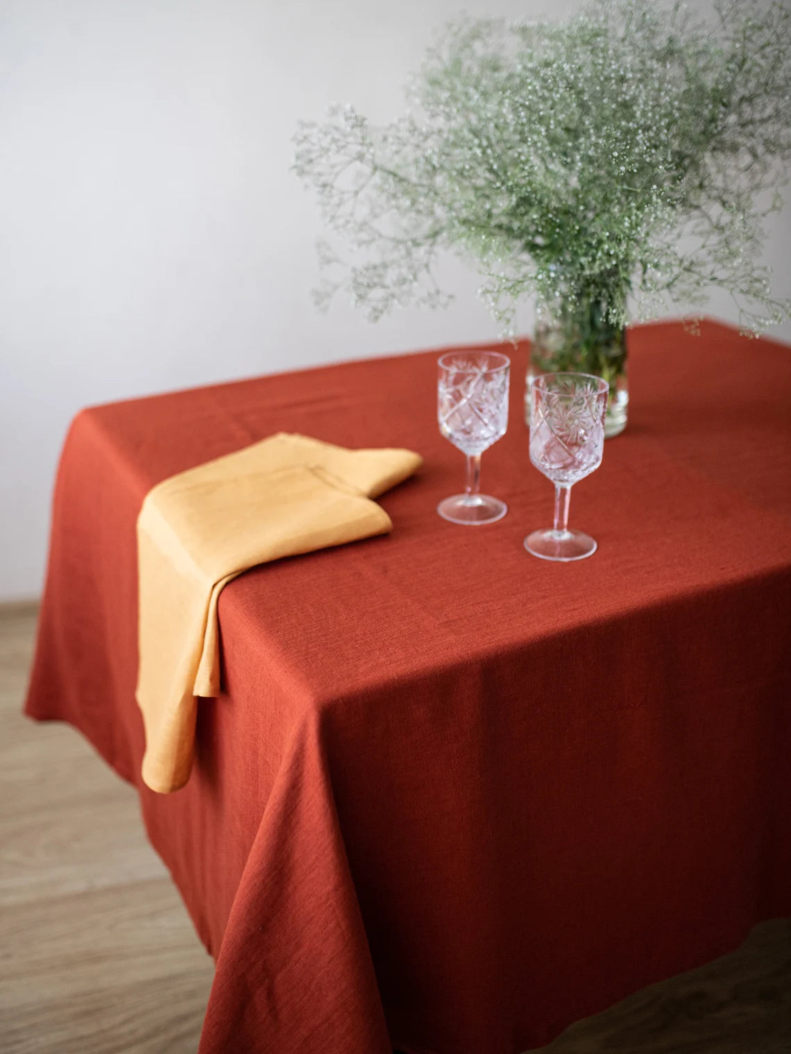 Burnt orange linen tablecloth with contrasting linen napkins on a dining table