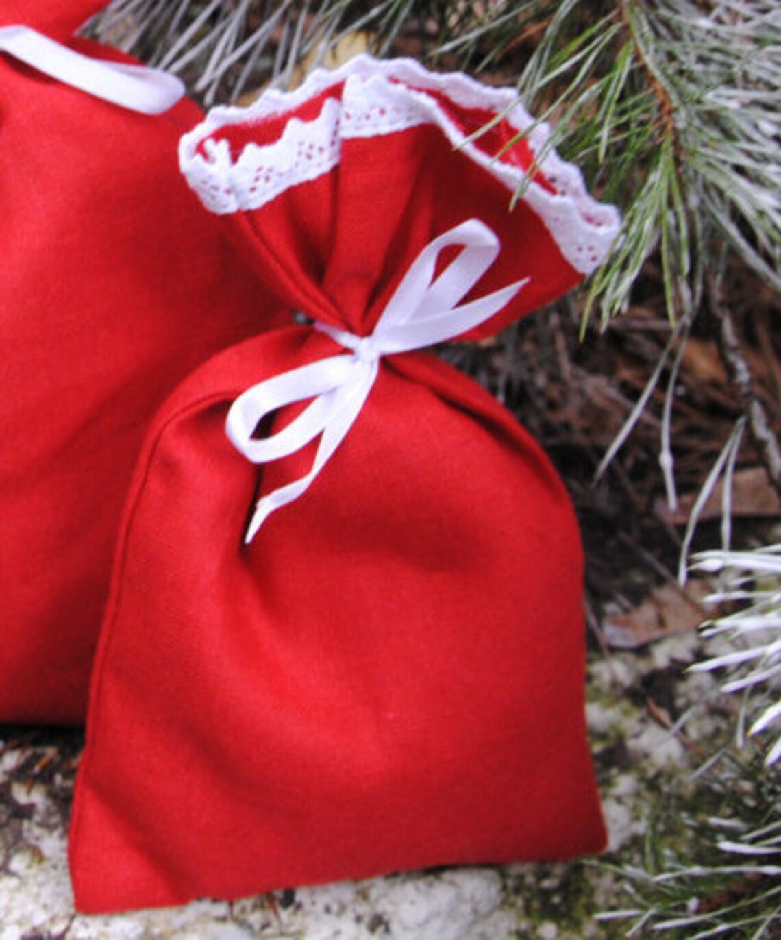 Handmade red Christmas gift bag with white lace and ribbon, reusable fabric gift wrapping for Christmas presents