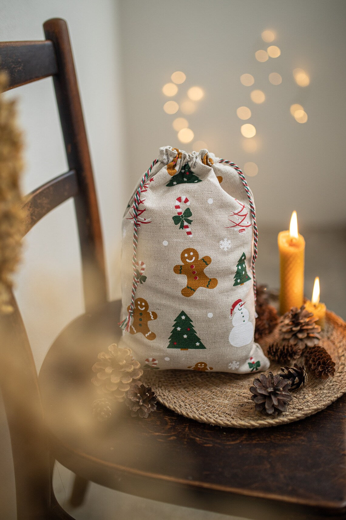 A small linen Christmas sack with a drawstring closure, printed with gingerbread men, Christmas trees, and snowmen