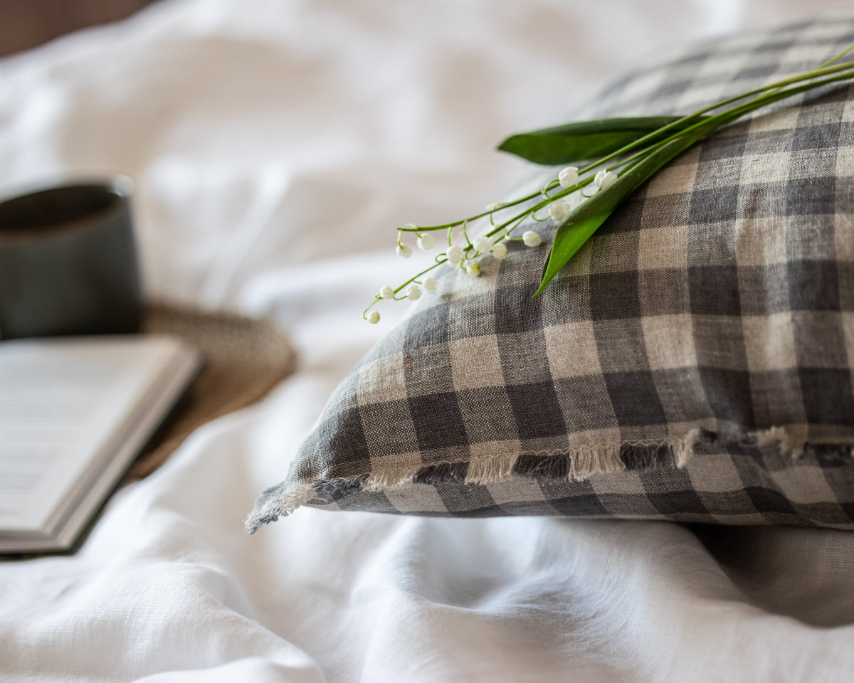 Plaid linen  pillow with flowers on a bed