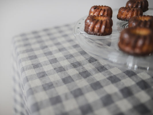 Mini bundt cakes in a clear silicone mold on a checkered linen  tablecloth.