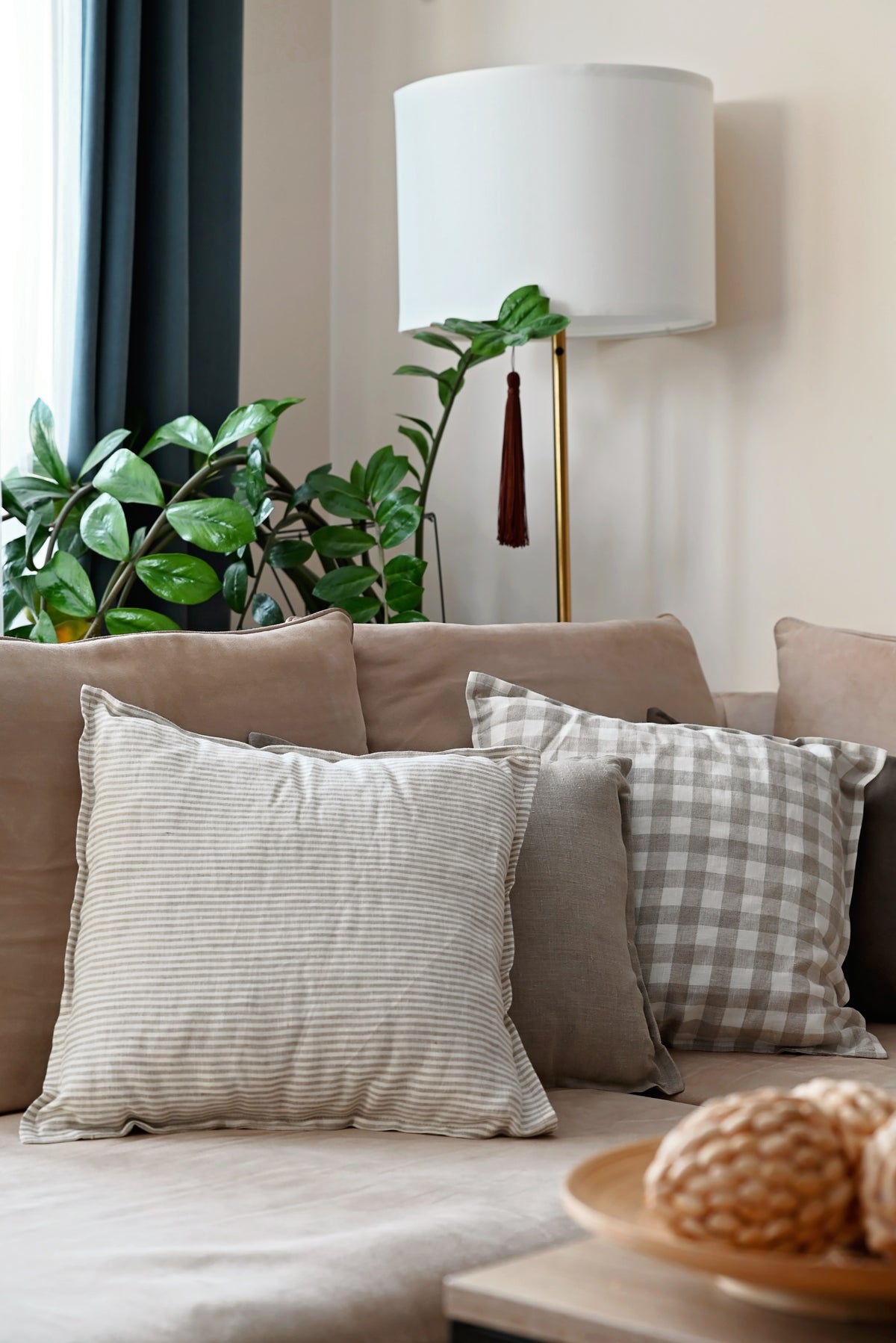 Decorative  linen pillows on a couch with a lamp and plants in the background