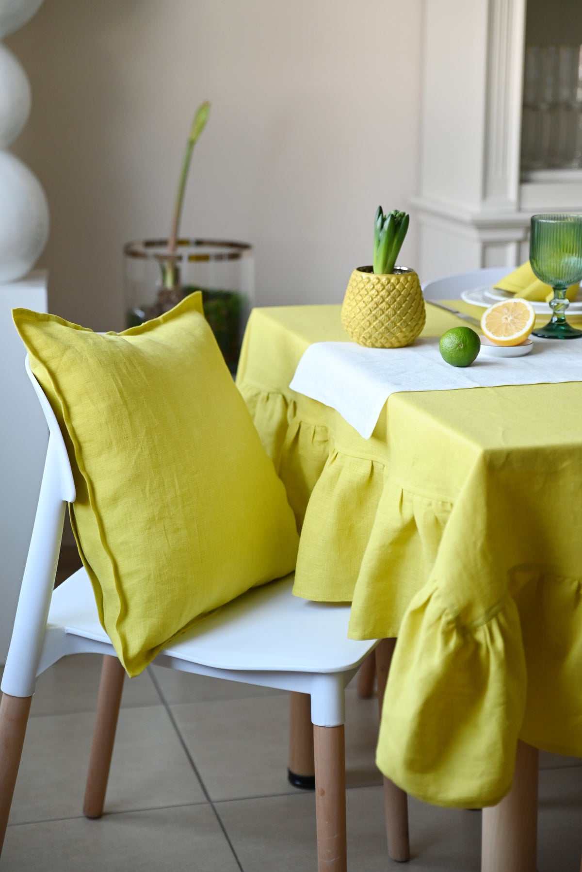 Chartreuse linen tablecloth and chair cover on a table with decorative items.