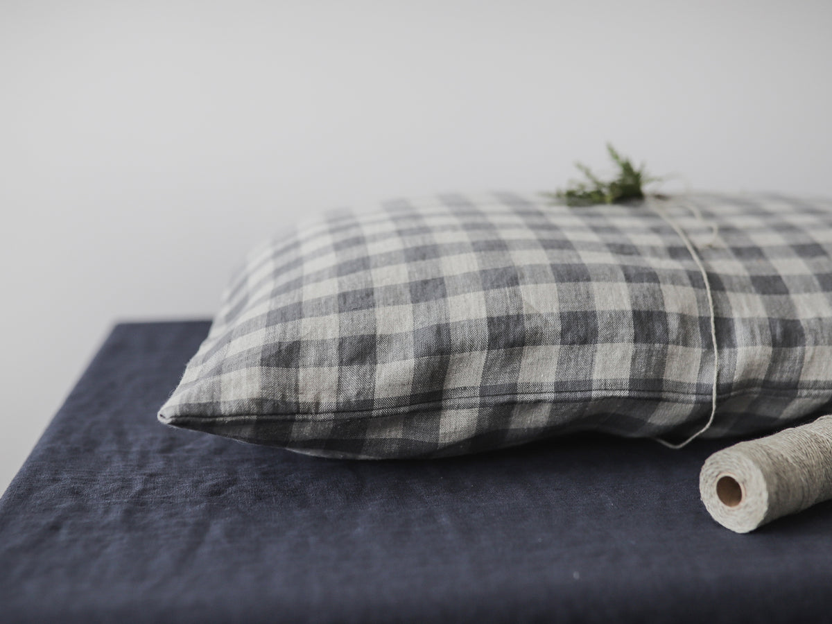 Plaid linen  pillow on a bed 