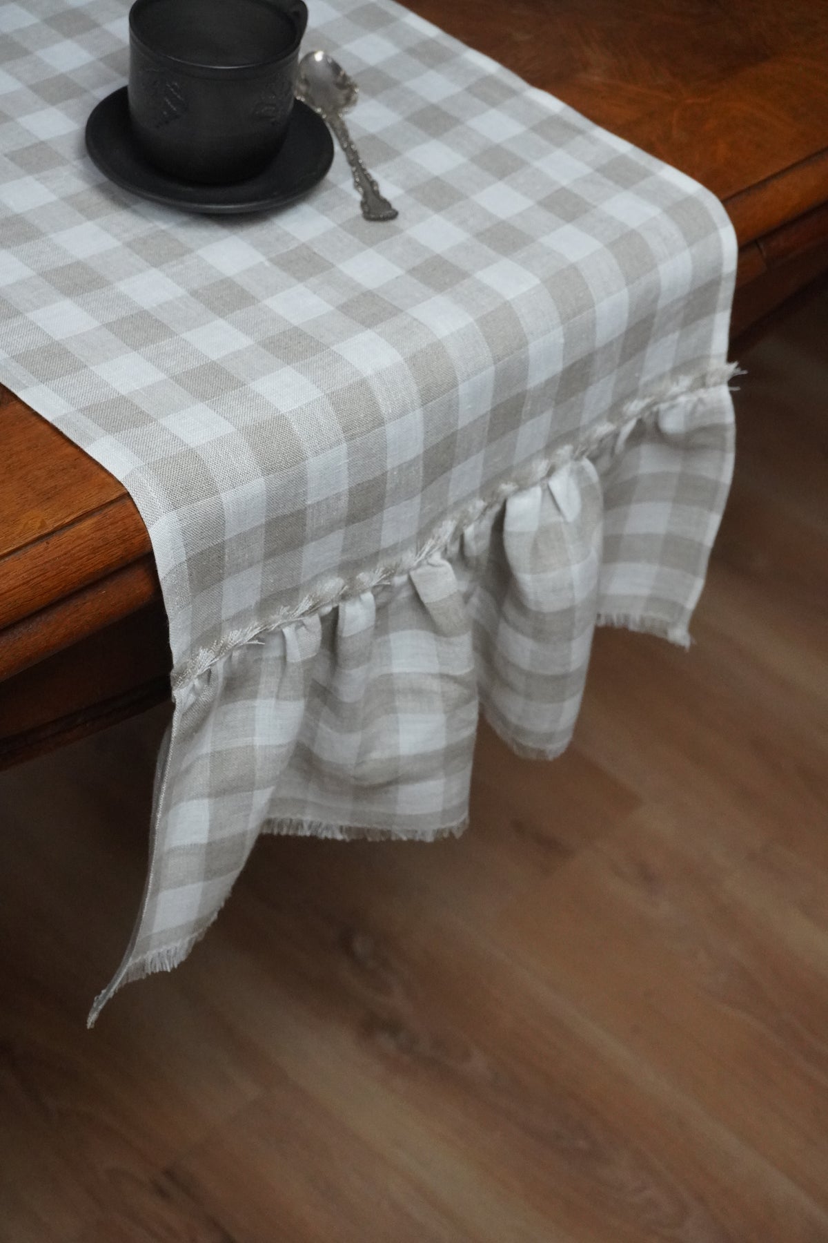 Checkered table runner with ruffled edge on a wooden table