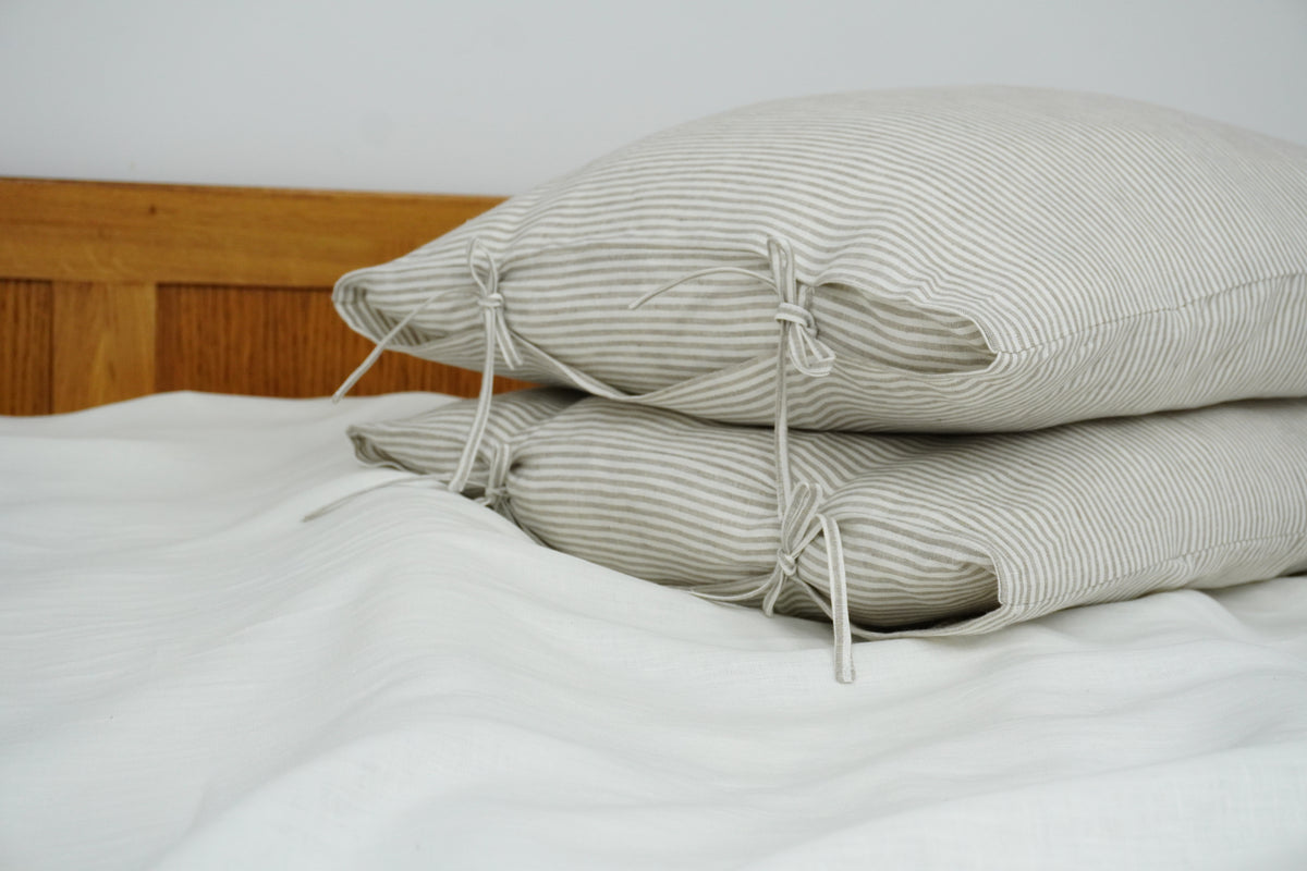 Striped pillows on a bed with a wooden headboard